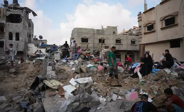 Palestinians inspect destroyed buildings at the site of an Israeli airstrike, at al-Maghazi refugee camp, central Gaza Strip, Friday, July 24, 2026. (AP Photo/Abdel Kareem Hana)