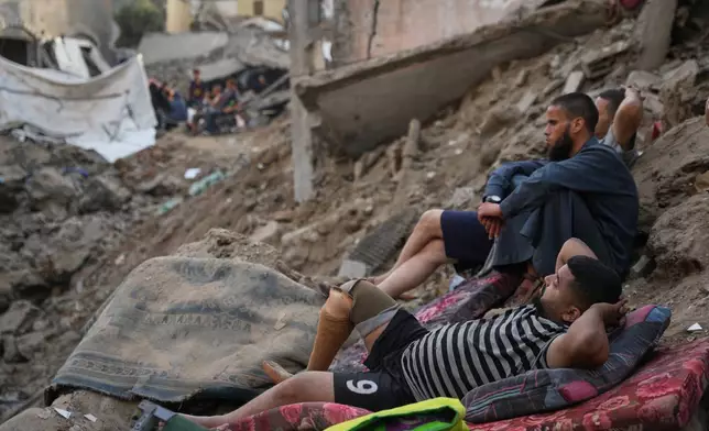 Palestinians inspect destroyed buildings at the site of an Israeli airstrike, at al-Maghazi refugee camp, central Gaza Strip, Friday, July 24, 2026. (AP Photo/Abdel Kareem Hana)