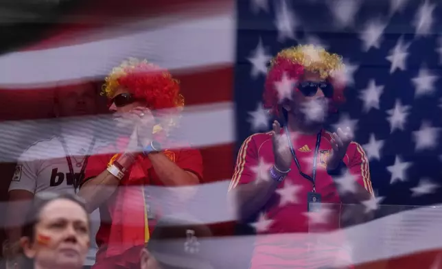An American flag is reflected in front of fans waiting for the World Cup round of 32 soccer match between Spain and Austria in Inglewood, Calif., near Los Angeles, Thursday, July 2, 2026. (AP Photo/Jae C. Hong)