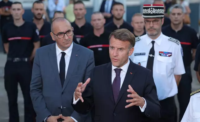 France's President Emmanuel Macron, center, speaks to the press next to Interior Minister Laurent Nunez, left, after a visit to the departmental fire and rescue operational center (CODIS) in Bordeaux, France, following wildfires in the area, Monday July 27, 2026. (Kenzo Tribouillard/Pool Photo via AP)