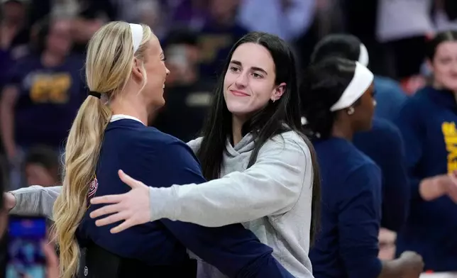 Indiana Fever guard Caitlin Clark, right, hugs Fever guard Sophie Cunningham during player introductions prior to a WNBA basketball game against the Phoenix Mercury, Thursday, July 9, 2026, in Phoenix. (AP Photo/Ross D. Franklin)