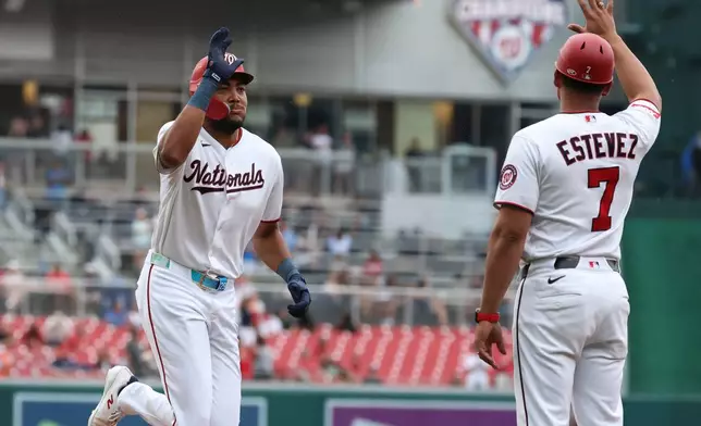 Washington Nationals' James Wood, left, is greeted by third base coach Victor Estevez (7) after hitting a home run off Houston Astros pitcher Tatsuya Imai during the first inning of a baseball game, Tuesday, July 7, 2026, in Washington. (AP Photo/Terrance Williams)