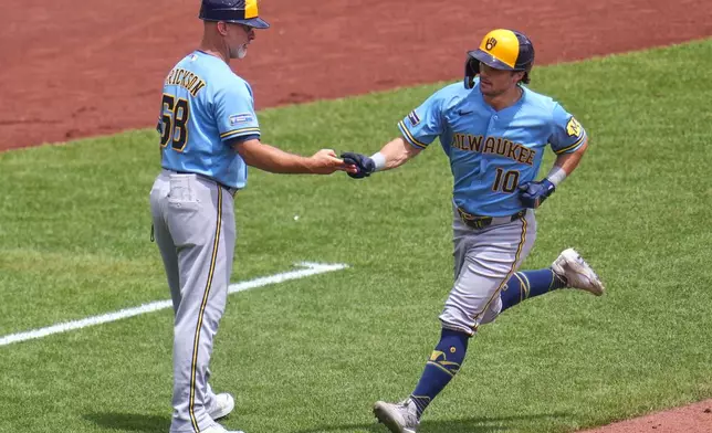 Milwaukee Brewers' Sal Frelick (10) rounds third to greetings from third base coach Matt Erickson (68) after hitting a two-run home run off Pittsburgh Pirates pitcher Braxton Ashcraft during the fifth inning of the first game of a baseball double header in Pittsburgh, Saturday, July 11, 2026. (AP Photo/Gene J. Puskar)