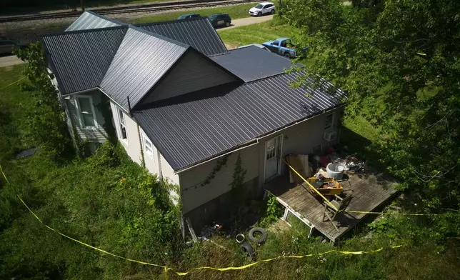 Police tape surrounds a home where authorities say they removed 16 children and arrested four adults in Hamden, Ohio, Wednesday, July 1, 2026. (AP Photo/Carolyn Kaster)
