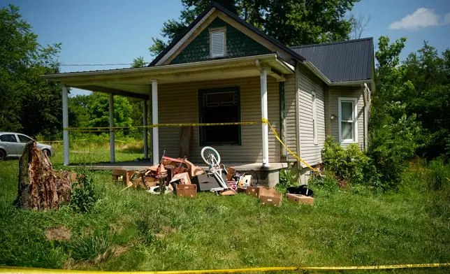 Police tape surrounds a home where authorities say they removed 16 children and arrested four adults in Hamden, Ohio, Wednesday, July 1, 2026. (AP Photo/Carolyn Kaster)