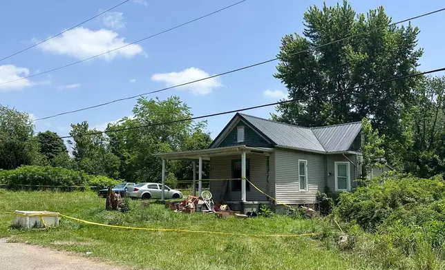 The dilapidated home where authorities say they removed 16 children and arrested four adults remains blocked off by crime scene tape on Wednesday, July 1, 2026 in Hamden, Ohio. (AP Photo/Julie Carr Smyth)