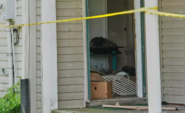 Items are seen beyond police tape in a home where authorities say they removed 16 children and arrested four adults in Hamden, Ohio, Wednesday, July 1, 2026. (AP Photo/Carolyn Kaster)