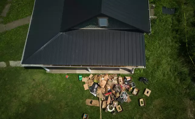 Debris is strewn on the front lawn of a home where authorities say they removed 16 children and arrested four adults in Hamden, Ohio, Wednesday, July 1, 2026. (AP Photo/Carolyn Kaster)