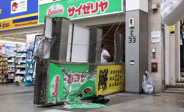A store sign of a restaurant is seen fallen on the ground after an earthquake in Kumamoto in the Kyushu island, southern Japan, Tuesday, July 28, 2026. (Kyodo News via AP)