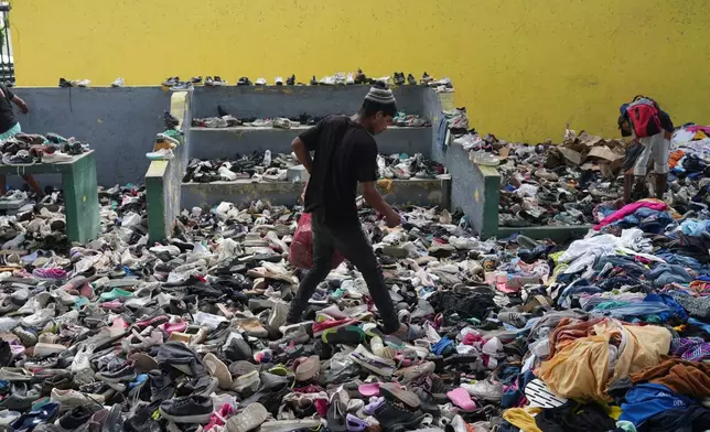 People choose clothes donated to those affected by the earthquakes at a sports complex in La Guaira, Venezuela, Saturday, July 4, 2026. (AP Photo/Ariana Cubillos)