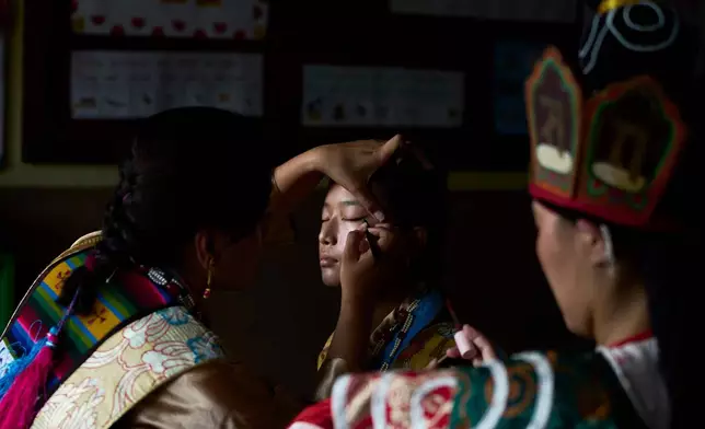 A Tibetan woman gets ready to perform at a cultural show during the 91st birthday celebration of spiritual leader the Dalai Lama in Kathmandu, Nepal, Monday, July 6, 2026. (AP Photo/Niranjan Shrestha)