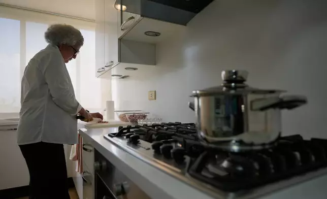 Anissa Helou, 74, one of the Middle East's most acclaimed cooks and food writers, prepares awarma, a traditional Lebanese lamb confit, at her late mother's apartment in the Mount Lebanon town of Ballouneh, Thursday, July 2, 2026. (AP Photo/Hussein Malla)