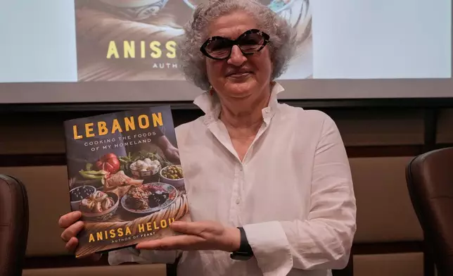 Anissa Helou, 74, one of the Middle East's most acclaimed cooks and food writers, holds her new book during a ceremony at the Lebanese Ministry of Tourism, in Beirut, Lebanon, Tuesday, June 23, 2026. (AP Photo/Hussein Malla)