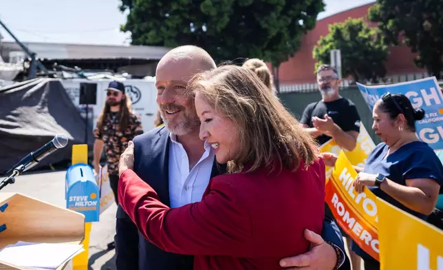 California Lt. Governor candidate Gloria Romero embraces California Republican gubernatorial candidate Steve Hilton, left, during a campaign event on Wednesday, July 22, 2026, in Los Angeles. (AP Photo/Ethan Swope)