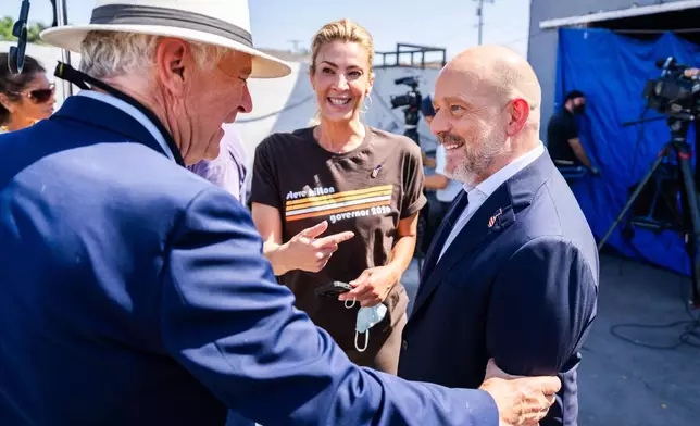 California Republican gubernatorial candidate Steve Hilton, right, talks to people after a campaign event on Wednesday, July 22, 2026, in Los Angeles. (AP Photo/Ethan Swope)