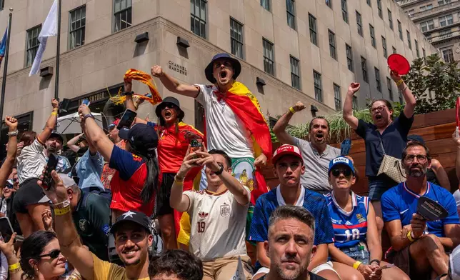 Spain fan reacts after the team scored their first goal during the World Cup semifinal soccer match between Spain and France at a watch party at the Rockefeller Center fan village, Tuesday, July 14, 2026, in New York. (AP Photo/Adam Gray)