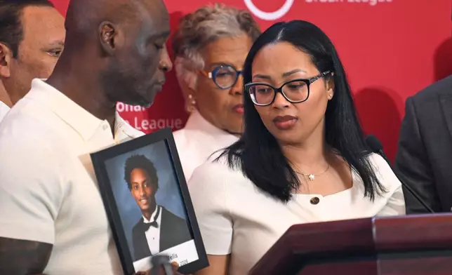 Christine Wonsley looks at a photo of her deceased son Nolan Wells, as husband Elmore Wonsley, left, stands at her side as they appear at the National Urban League's annual conference, Thursday, July 30, 2026, in Nashville, Tenn. (AP Photo/John Amis)