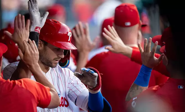 Philadelphia Phillies' Trea Turner, left, celebrates his two-run home run with teammates in the dugout during the second inning of a baseball game against the Los Angeles Dodgers, Monday, July 20, 2026, in Philadelphia. (AP Photo/Chris Szagola)