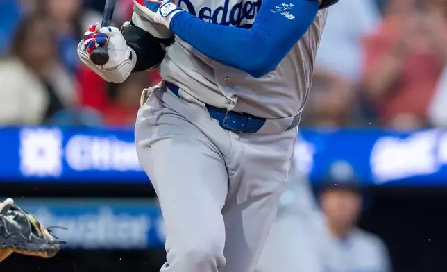 Los Angeles Dodgers' Shohei Ohtani reacts to fouling the ball off his body during the third inning of a baseball game against the Philadelphia Phillies, Monday, July 20, 2026, in Philadelphia. (AP Photo/Chris Szagola)