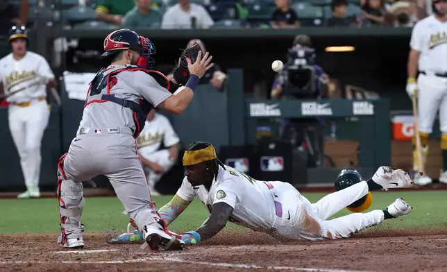 Boston Red Sox catcher Connor Wong, left, attempts to get Athletics' Lawrence Butler (4) out at home plate during the sixth inning of a baseball game Thursday, July 30, 2026, in West Sacramento, Calif. (AP Photo/Sara Nevis)