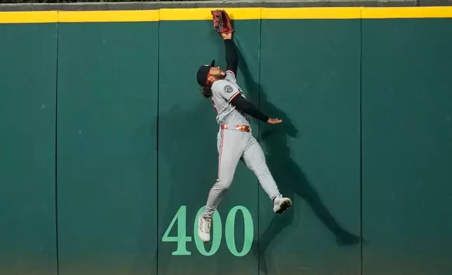 Minnesota Twins center fielder Austin Martin jumps for but can't get to a ball hit for a home run by Cleveland Guardians' Patrick Bailey in the seventh inning of a baseball game in Cleveland, Monday, July 20, 2026. (AP Photo/Sue Ogrocki)