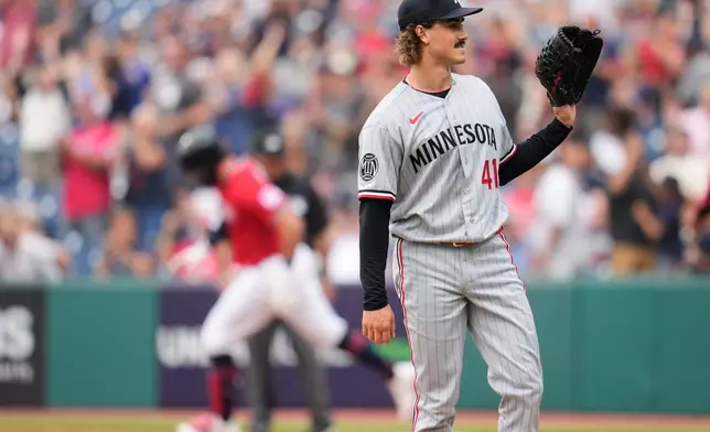 Minnesota Twins pitcher Joe Ryan (41) waits for a new ball as Cleveland Guardians' Rhys Hoskins, left, runs the bases after hitting a home run in the first inning of a baseball game in Cleveland, Monday, July 20, 2026. (AP Photo/Sue Ogrocki)