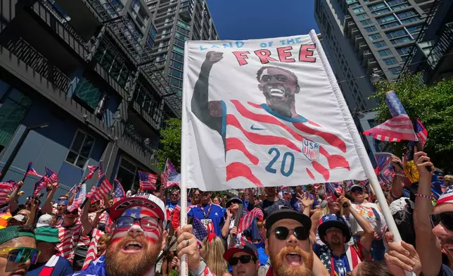 United States soccer fans, one holding a sign for United States' Folarin Balogun (20) react during the World Cup round of 16 soccer match between the United States and Belgium in Seattle, Monday, July 6, 2026. (AP Photo/Eric Hiller)