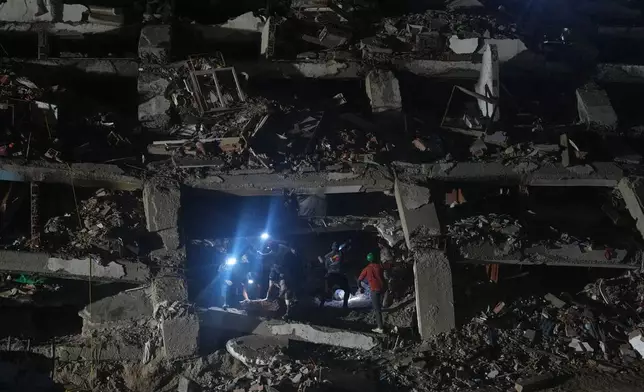 Relatives and rescue workers search through a collapsed building by the earthquakes for their love ones in La Guaira, Venezuela, Tuesday, July 21, 2026. (AP Photo/Ariana Cubillos)