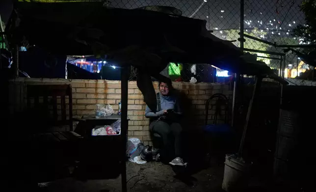 Estefany Landaez sits at a makeshift tent close the area of the building where she lost her two children, her mother, brother, and nephew, after collapse during the earthquakes in La Guaira, Venezuela, Tuesday, July 21, 2026. (AP Photo/Ariana Cubillos)