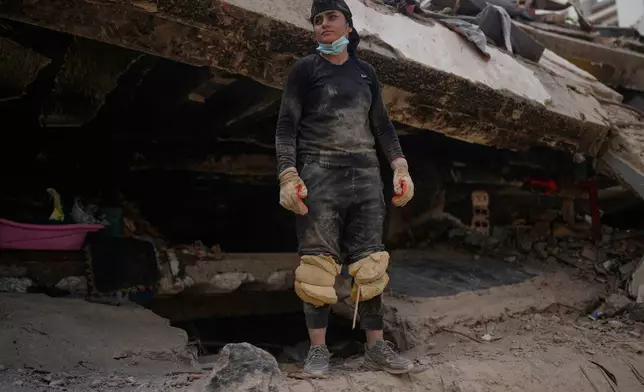 Maria Morales stands on a collapsed building by the earthquakes, searchig for her aunt Yaeina Vera in La Guaira, Venezuela, Thursday, July 23, 2026. (AP Photo/Ariana Cubillos)