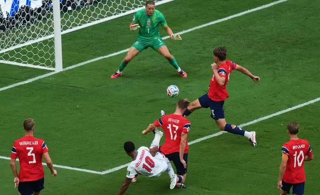 England's Jude Bellingham (10) scores their first goal past Norway goalkeeper Oerjan Nyland (1) during the World Cup quarterfinal soccer match between Norway and England in Miami Gardens, Fla., Saturday, July 11, 2026. (AP Photo/Marta Lavandier)