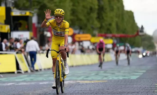 Slovenia's Tadej Pogacar, wearing the overall leader's yellow jersey, celebrates as he crosses the finish line of the last stage of the Tour de France cycling race with start and finish in Paris, Sunday, July 26, 2026. (AP Photo/Mosa'ab Elshamy)
