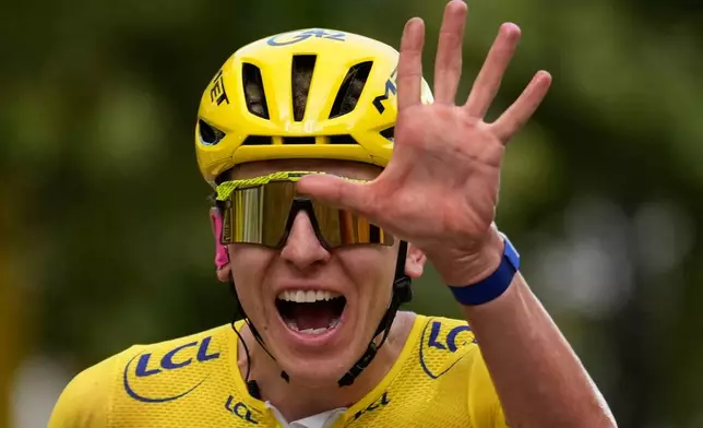Slovenia's Tadej Pogacar, wearing the overall leader's yellow jersey, celebrates as he crosses the finish line of the last stage of the Tour de France cycling race with start and finish in Paris, Sunday, July 26, 2026. (AP Photo/Mosa'ab Elshamy)