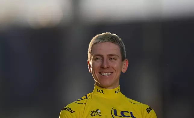 Slovenia's Tadej Pogacar, wearing the overall leader's yellow jersey, celebrates on the podium after the last stage of the Tour de France cycling race with start and finish in Paris, Sunday, July 26, 2026. (AP Photo/Thibault Camus)