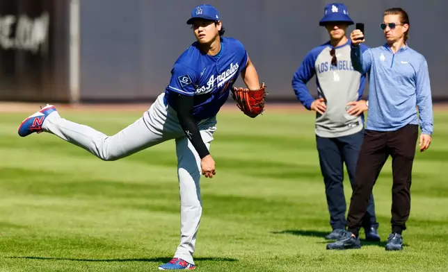 Los Angeles Dodgers' Shohei Ohtani, left, throws in the outfield before the second game of a baseball doubleheader against the New York Yankees, Sunday, July 19, 2026, in New York. (AP Photo/Noah K. Murray)