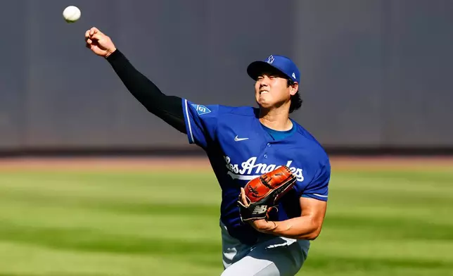 Los Angeles Dodgers' Shohei Ohtani throws in the outfield before the second game of a baseball doubleheader against the New York Yankees, Sunday, July 19, 2026, in New York. (AP Photo/Noah K. Murray)