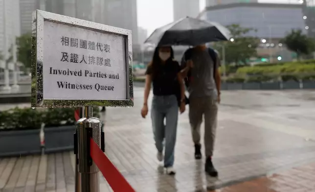 Member of the public arrives for the closing submissions at the Independent Commission investigation hearing into last year's Tai Po deadly fire, in Hong Kong, Friday, July 17, 2026. (AP Photo/May James)