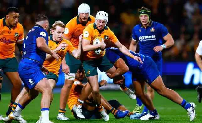 Australia's Declan Meredith, center, is tackled while making a run against Italy during their Nations Championship rugby international test match in Perth, Australia, Saturday, July 18, 2026. (AP Photo/Gary Day)