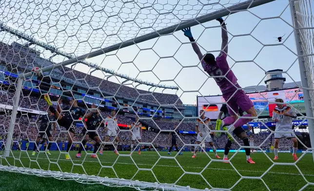 Paraguay goalkeeper Orlando Gill (12) fails to save a header from Germany's Jonathan Tah (4) for a goal that was disqualified after a VAR check during the World Cup round of 32 soccer match between Germany and Paraguay in Foxborough, Mass., near Boston, Monday, June 29, 2026. (AP Photo/Petr Josek)