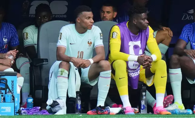 France's Kylian Mbappe, left, sits on the bench with his right lower ankle region wrapped during the World Cup quarterfinal soccer match between France and Morocco in Foxborough, Mass., near Boston, Thursday, July 9, 2026. (AP Photo/Stephanie Scarbrough)