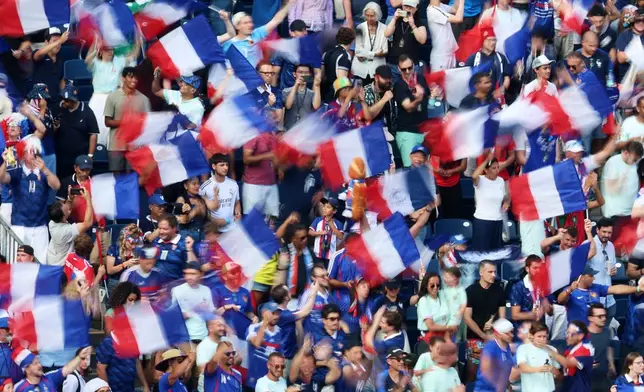 In this photo taken with slow shutter speed, fans celebrate as France defeats Morocco during the World Cup quarterfinal soccer match in Foxborough, Mass., near Boston, Thursday, July 9, 2026. (AP Photo/Mark Stockwell)