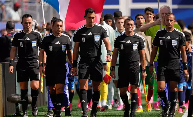 From left, reserve assistant referee Cristian Navarro, assistant referee Juan Pablo Belatti, referee Facundo Tello, assistant referee Gabriel Chade and fourth official Dario Herrera take to the field before the World Cup quarterfinal soccer match between France and Morocco in Foxborough, Mass., near Boston, Thursday, July 9, 2026. (AP Photo/Charles Krupa)