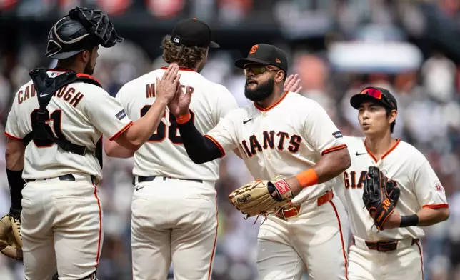 San Francisco Giants left fielder Heliot Ramos, second from right, celebrates with teammates after a baseball game against the Colorado Rockies, Sunday, July 12, 2026, in San Francisco. (AP Photo/Thien-An Truong)