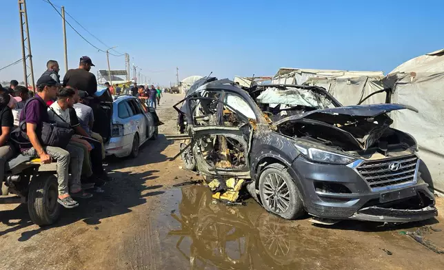 Palestinians look at a destroyed car following an Israeli military strike in Khan Younis, southern Gaza Strip, Monday, July 6, 2026, that, according to hospital officials, killed at least one person. (AP Photo/Mohammad Jahjouh)