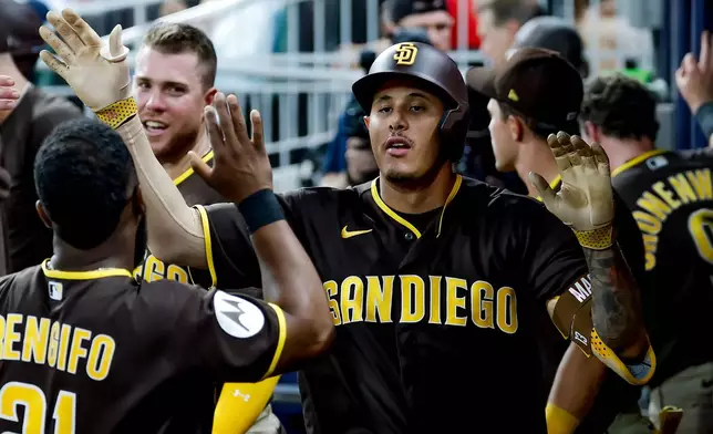 San Diego Padres' Manny Machado is greeted in the dugout after hitting a solo home run against the Atlanta Braves during the sixth inning of a baseball game, Tuesday, July 21, 2026, in Atlanta. (AP Photo/Erik S. Lesser)