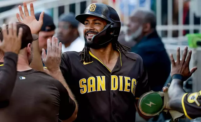 San Diego Padres' Fernando Tatis Jr. is greeted in the dugout after scoring against the Atlanta Braves during the first inning of a baseball game, Tuesday, July 21, 2026, in Atlanta. (AP Photo/Erik S. Lesser)