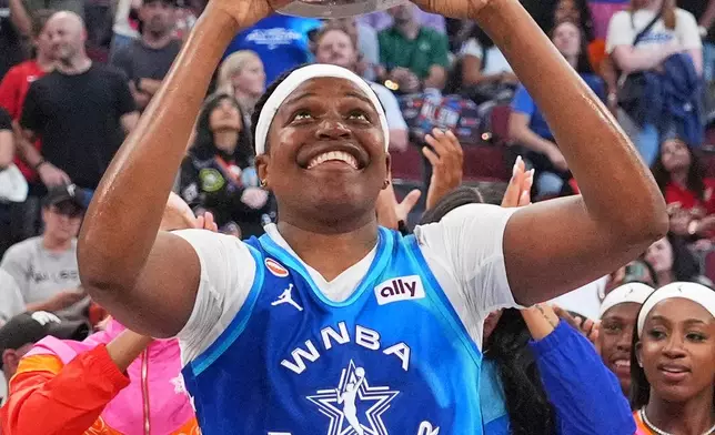 Team Spoon's Jonquel Jones smiles as she holds up the MVP trophy after Team Spoon defeated Team Cooper in a WNBA All-Star basketball game in Chicago, Saturday, July 25, 2026. (AP Photo/Nam Y. Huh)