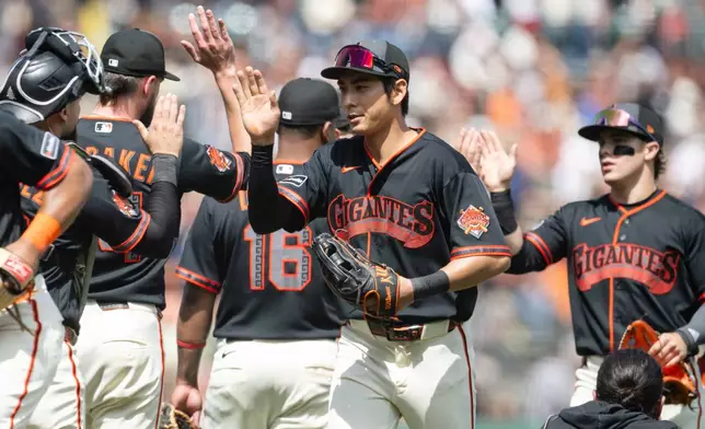 San Francisco Giants right fielder Jung Hoo Lee (51), middle, reacts after winnning a baseball game against the Colorado Rockies Saturday, July 11, 2026, in San Francisco. (AP Photo/Thien-An Truong)