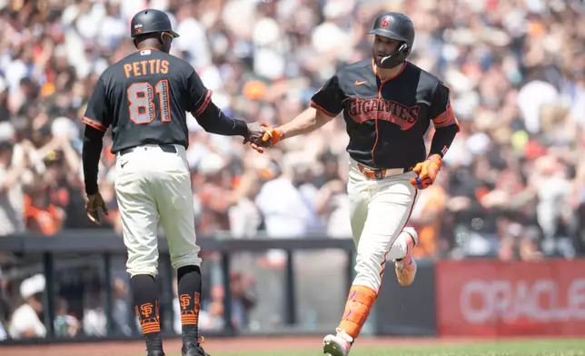 San Francisco Giants' Casey Schmitt (10), right, rounds the bases after hitting a three-run home run during the sixth inning of a baseball game against the Colorado Rockies Saturday, July 11, 2026, in San Francisco. (AP Photo/Thien-An Truong)