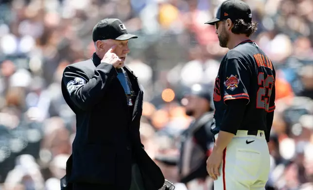 San Francisco Giants manager Tony Vitello (23), right, speaks with home plate umpire Lance Barksdale, left, after Colorado Rockies' Brett Sullivan (26) scores on a balk by San Francisco Giants pitcher Tyler Mahle during the third inning of a baseball game Saturday, July 11, 2026, in San Francisco. (AP Photo/Thien-An Truong)